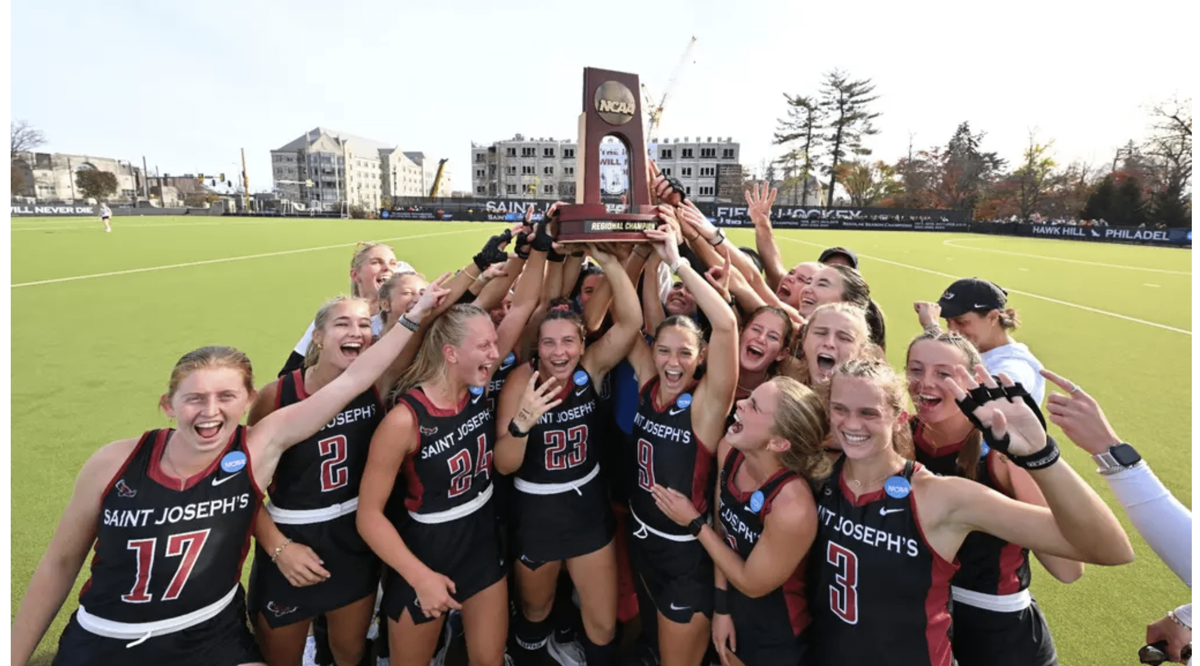 The St. Joe's field hockey team, holds up a trophy as they celebrate their NCAA Final Four berth.